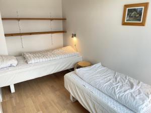 斯凯恩Skjernaa-ferie/ Andersen Invest的配有白色墙壁和木地板的客房内的两张床