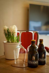 贝拉克尔Boutique Hotel De Brakelhoen的桌子上放着两瓶啤酒和一杯葡萄酒
