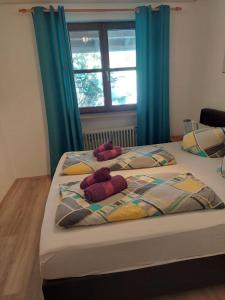 瓦尔兴湖Ferienwohnung am Walchensee的卧室内的两张床,配有蓝色窗帘