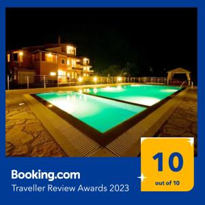 DafnilaCaptain Alex Villa 2的夜间大型游泳池,上面有旅行评审奖的标志