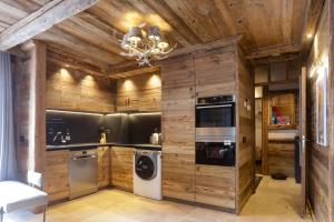 卡尼略Résidence Deu Sol appartement Chalet Vall d Incles的厨房设有木墙、洗衣机和烘干机。