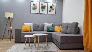 皮罗特Vila Harmony的客厅配有灰色的沙发和2张桌子