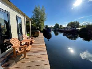 芬克芬NEW - Private Cabin - on a lake near Amsterdam的两个长椅坐在水边的码头上