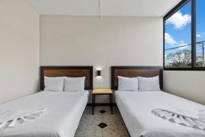 梅里达Suites Reforma by HomiRent的带2扇窗户的客房内的2张床