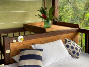 努基La Kuka Hotel - Nuquí的一间卧室配有一张床和一张植物桌子