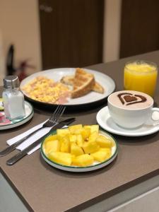卡利Reset (Hotel-Cafe-Coworking)的餐桌,包括两盘早餐食品和一杯咖啡