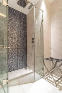 胡志明市The Rixx Central @ Park Hyatt/SmartTV65in/Netflix的浴室内带椅子的玻璃淋浴间