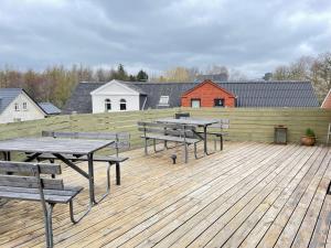 斯凯恩Skjernaa-ferie/ Andersen Invest的木甲板上的一组野餐桌