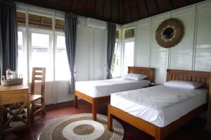 LabuberuPASERANG PARIRI PARADISE的一间卧室设有两张床、一张桌子和窗户。