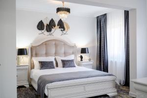 特尔古尼亚姆茨Tesa Boutique Hotel的一间卧室配有一张带2个床头柜的大型白色床