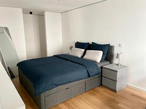 慕尼黑Modern Apartment in the center of Munich的一间卧室配有一张带蓝色床单的床和床头柜。