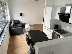 慕尼黑Modern Apartment in the center of Munich的厨房以及带桌子和沙发的客厅。