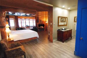 圣阿加瑟莫奥克斯内特斯日维酒店的一间卧室设有一张大床和一个壁炉