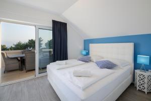 波尔地中海别墅的一间带一张白色大床的卧室和一个阳台