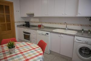 昆卡AP Plaza la Hispanidad的厨房配有桌子、水槽和洗衣机。
