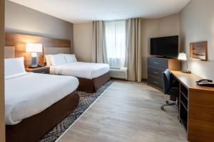 马纳萨斯马纳萨斯烛木套房酒店的酒店客房设有两张床、一张桌子和一台电视。