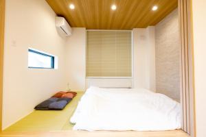 俱知安町Queens Park CK VILLAGE Niseko Hirafu的卧室配有白色的床和窗户。