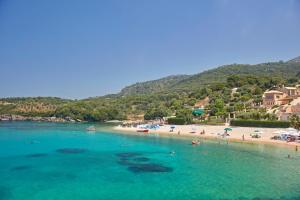 塞沃塔Sivota Seascape Luxury Villas & Residences的和水中的人一起欣赏海滩的景色
