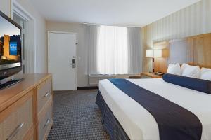 棕榈泉棕榈泉品质旅馆的一间酒店客房,配有一张大床和一台平面电视