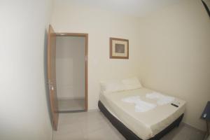 坎普斯戈伊塔卡济斯Hotel hawaii的一间小卧室,配有一张床和镜子