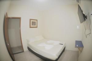 坎普斯戈伊塔卡济斯Hotel hawaii的一间小卧室,配有一张床和电视