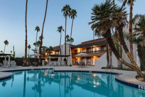 棕榈泉棕榈泉品质旅馆的一座拥有游泳池和棕榈树的酒店