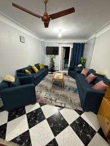 亚历山大Appartement à Miami - Vu sur mer的客厅设有蓝色的沙发和 ⁇ 格地板