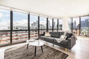 墨尔本KULA Docklands的带沙发和大窗户的客厅