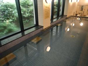 奈良奈良日航国际酒店的大堂设有窗户,地面铺有瓷砖地板,配有灯光