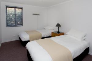 Quorrobolong猎人谷假日公园的一间卧室设有两张床和窗户。