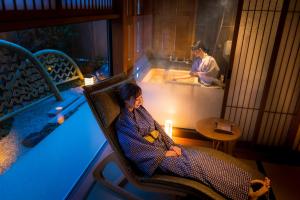 尾道市Onomichi Hansei的浴缸旁的椅子上的女人