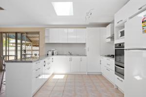 卡尔古利Bea-Vic Home. Your home away from home.的白色的厨房配有白色橱柜和瓷砖地板。