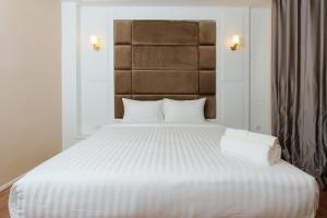 乌隆他尼Calinton Hotel的卧室配有白色床单和白色大床