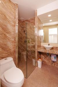乌隆他尼Calinton Hotel的浴室配有卫生间、淋浴和盥洗盆。