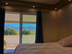 瓜达鲁佩镇Mi Casa en el Valle de Guadalupe的一间卧室设有一张床和一个美景窗户。