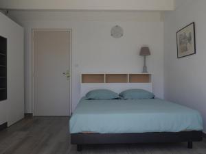 班戈Maison Bangor, 3 pièces, 4 personnes - FR-1-418-215的一间卧室配有一张带白色床单和蓝色枕头的大床。