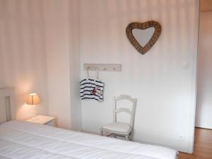 勒帕莱Maison Le Palais, 3 pièces, 4 personnes - FR-1-418-220的卧室配有一张床,墙上挂着心