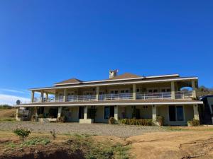 瓜达鲁佩镇Mi Casa en el Valle de Guadalupe的大型白色房屋,设有大型门廊