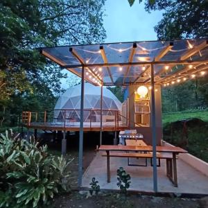 比加瓜Bitzu Dome-Bijagua Riverside Glamping的凉亭配有野餐桌和帐篷