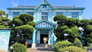 MitoyoLe Port Awashima的前面有树木的蓝色房子