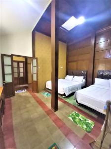 梭罗Ndalem Kinasih Homestay Syariah的一间酒店客房,房间内设有两张床