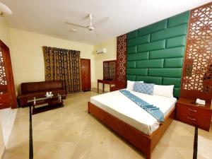 卡拉奇Hotel Imperial Karachi的一间卧室配有一张带绿色墙壁的床