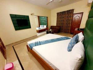 卡拉奇Hotel Imperial Karachi的一间卧室配有一张大床和电视