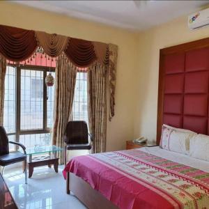 卡拉奇Hotel Imperial Karachi的一间卧室配有一张床、一把椅子和窗户。