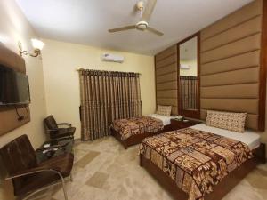 卡拉奇Hotel Imperial Karachi的酒店客房设有两张床和一台平面电视。