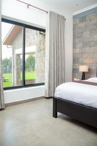 KinigiFoothills Farmhouse Musanze, Rwanda的一间卧室设有一张床和一个大窗户