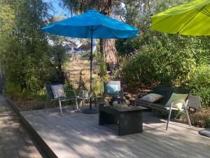 赫本温泉渡鸦Spa套房的庭院配有椅子、蓝伞和桌子