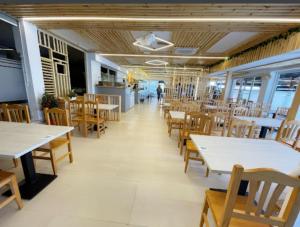 雷阿尔城埃尔莫利诺酒店的餐厅设有白色的桌子和木椅