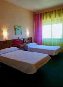 雷阿尔城埃尔莫利诺酒店的酒店客房设有两张床和窗户。