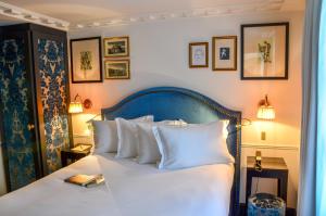 巴黎拉尚布热马莱斯酒店的一间卧室配有带白色枕头的床